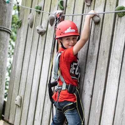 Kind klettert in einer Boulderwand
